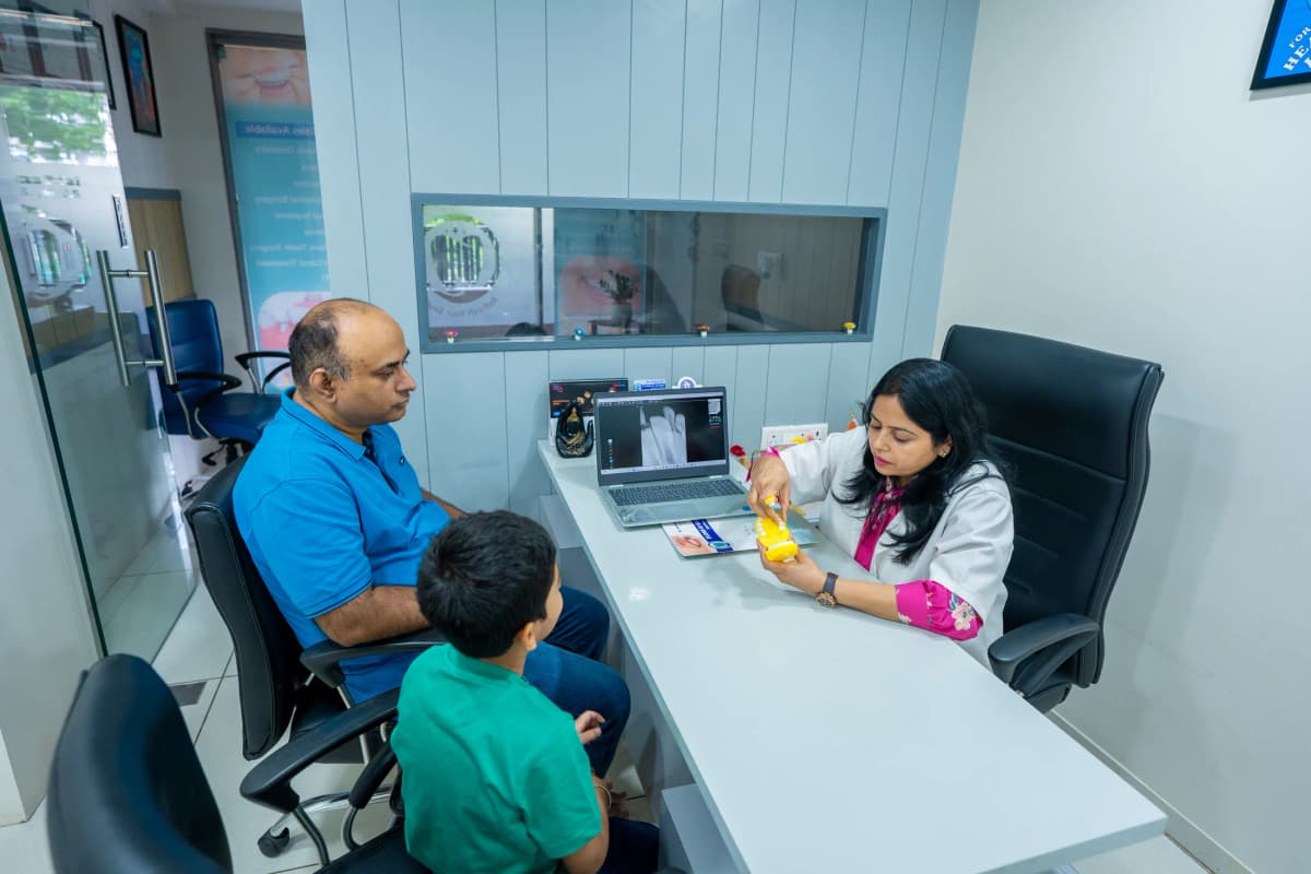 Dr. Archana explaining dental care to a parent and child